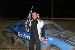 Brett Norman with the Chequered Flag – Photo courtesy of Vern & Jackie Parker